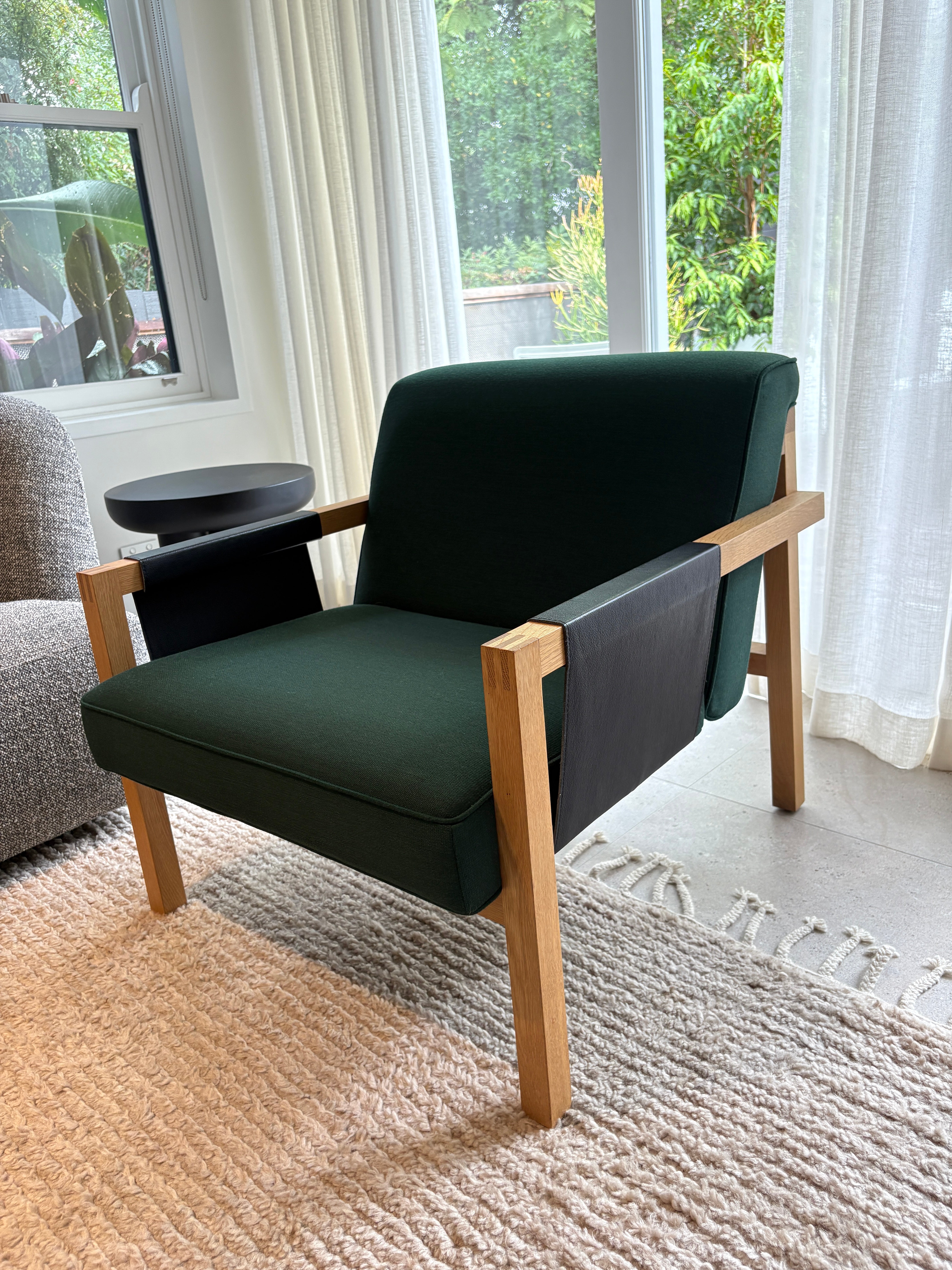 Green armchair with wood frame in a living room setting