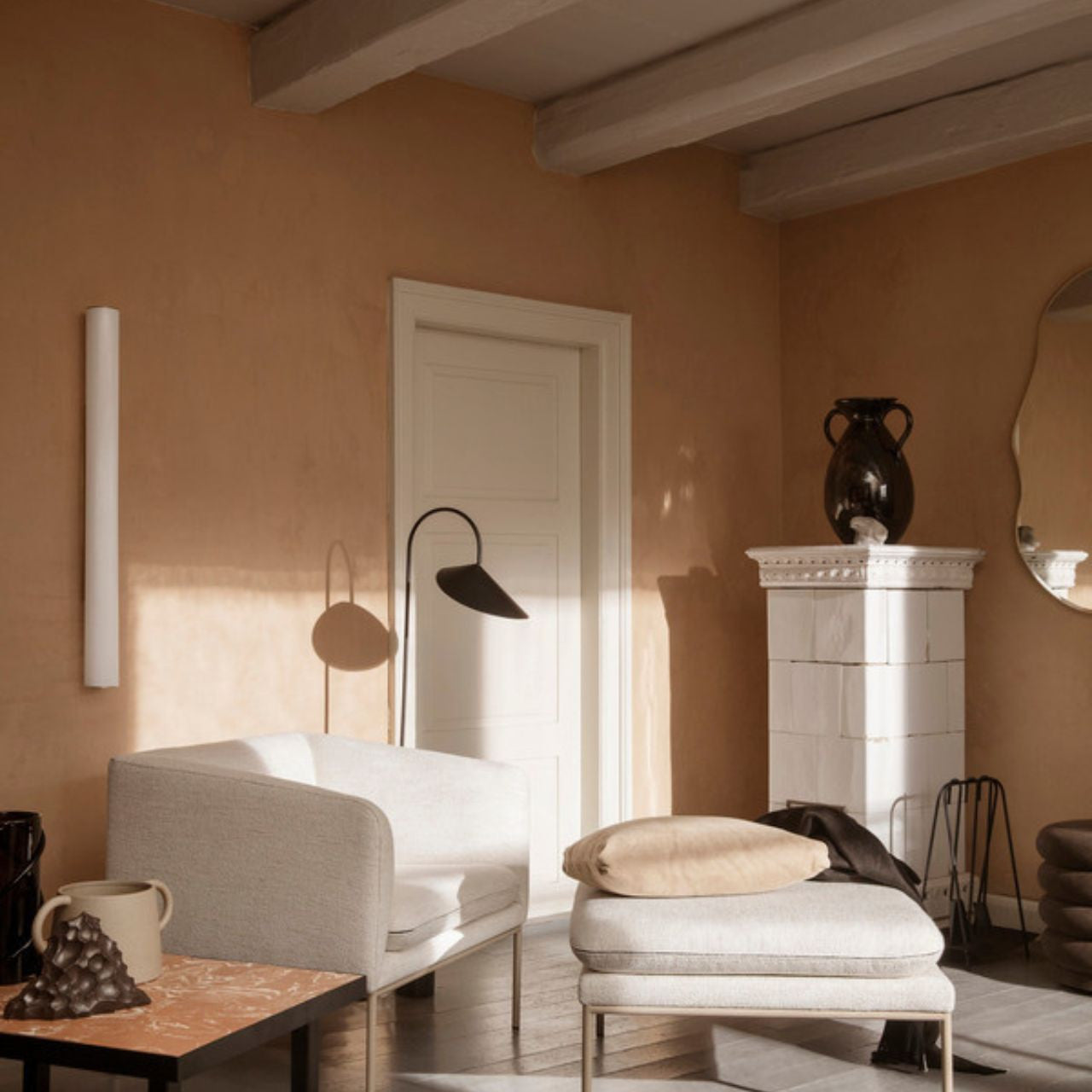 Modern living room with beige walls, a white sofa, and decorative items.