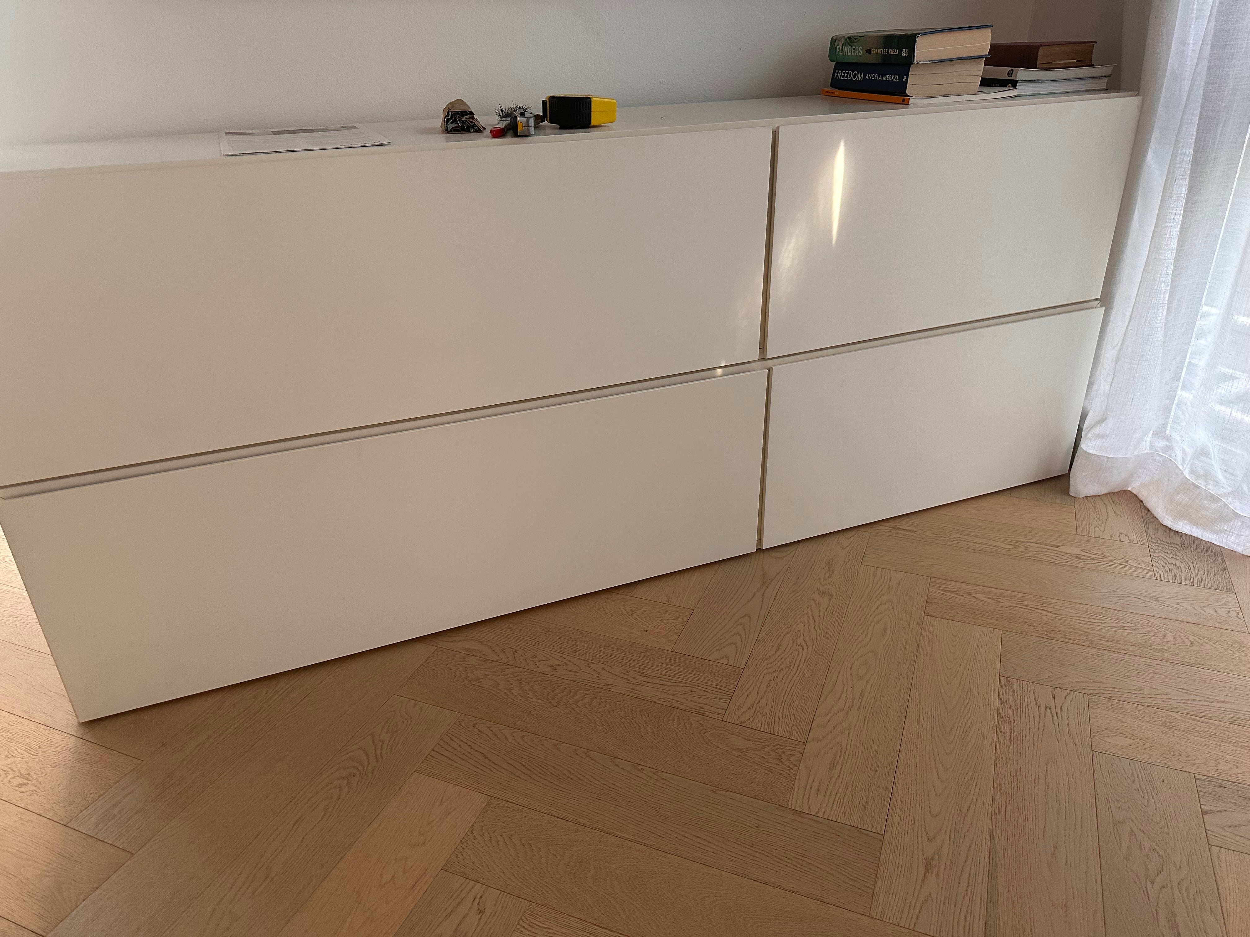 White storage unit with glass panels on a wooden floor