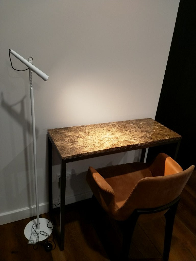 Modern floor lamp with a textured shade on a white surface.