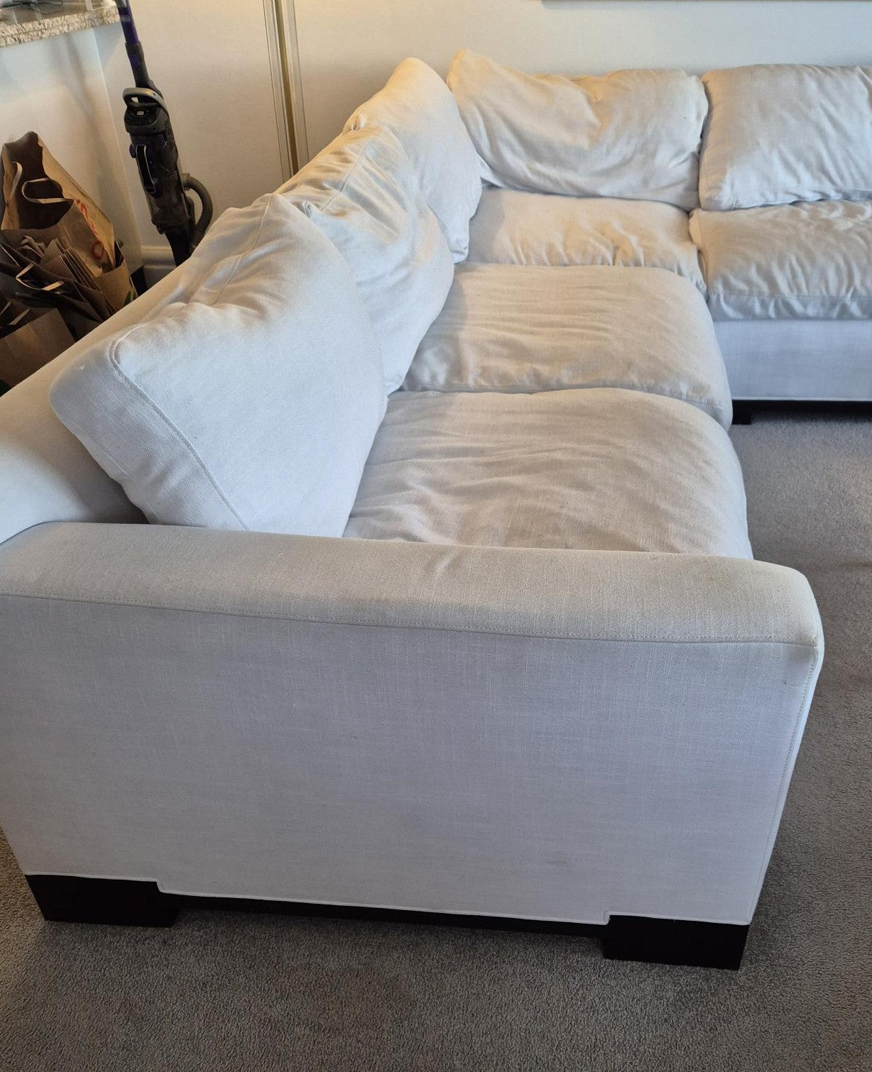 White sectional sofa in a room with a neutral color scheme.