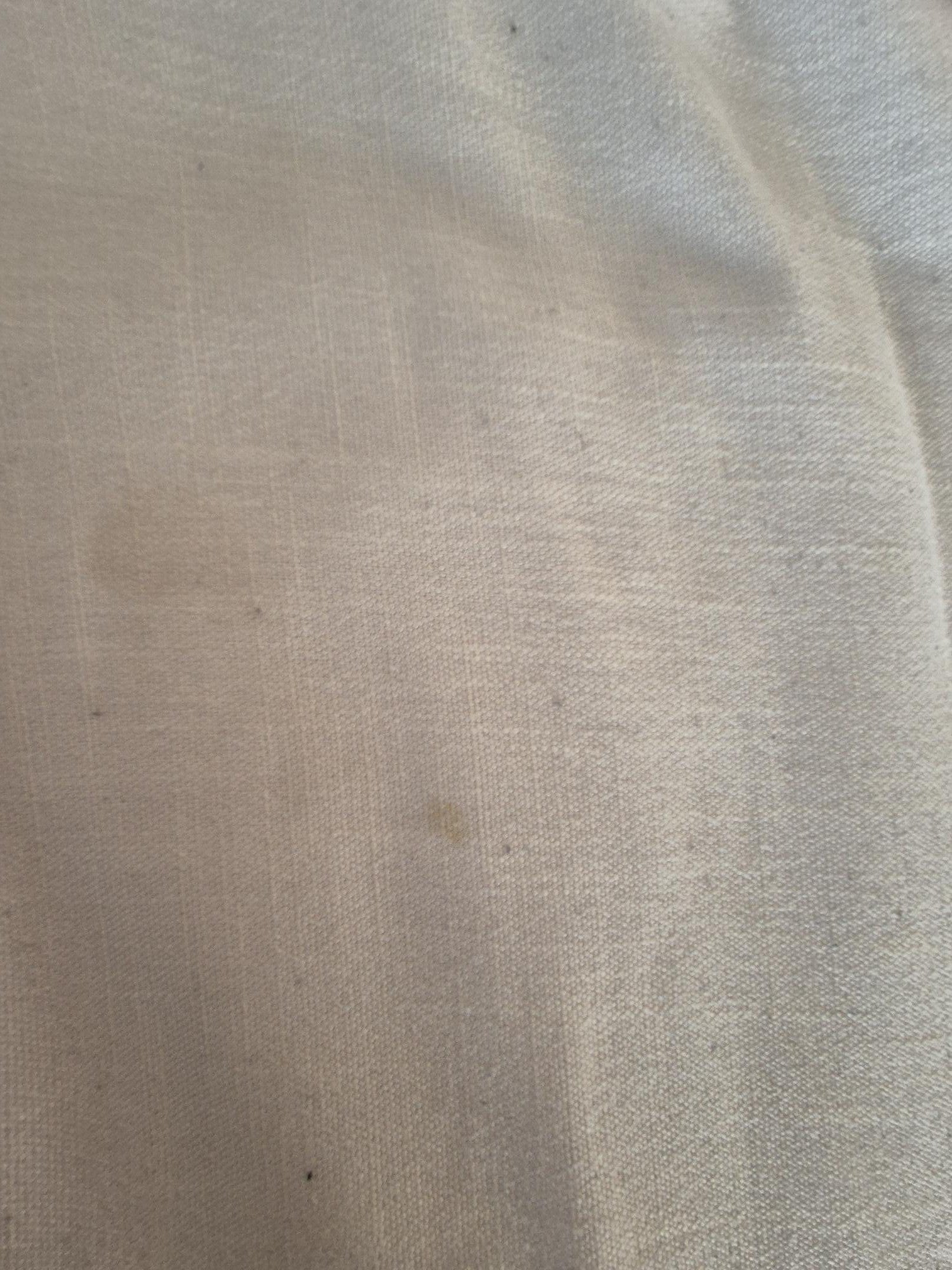 Close-up of a beige fabric with a stain on a light background