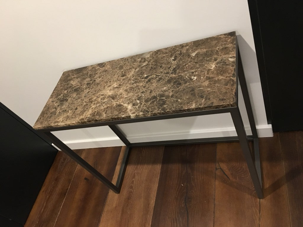 Marble-top console table with metal legs on a wooden floor.