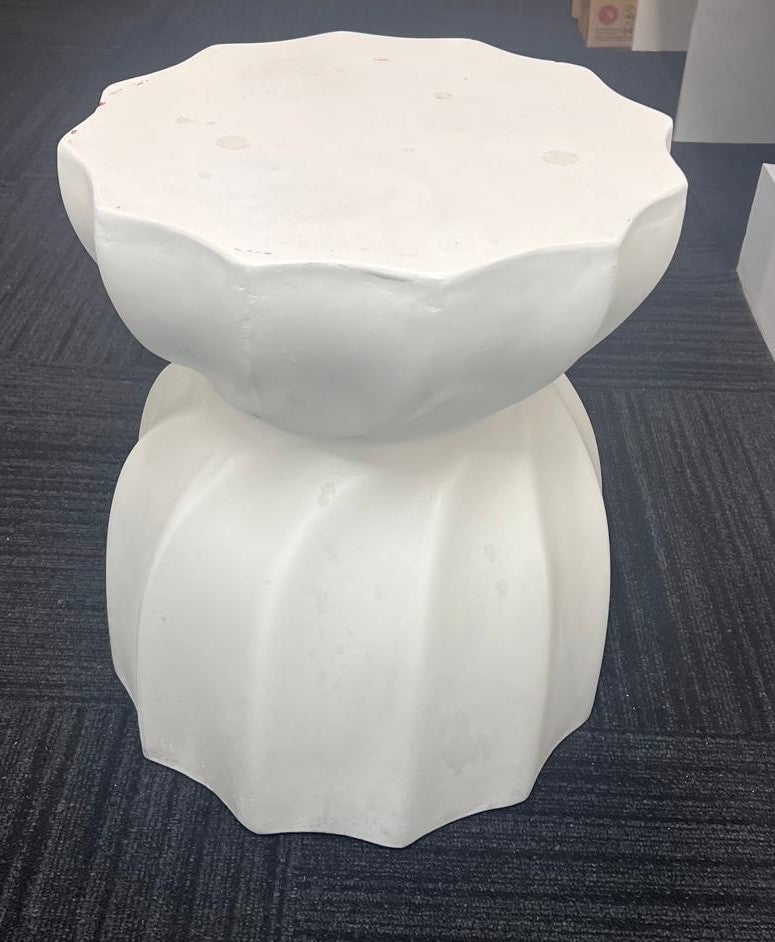 White stone sculpture on a textured blue surface