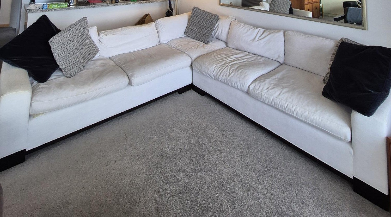 White sectional sofa with cushions in a living room setting