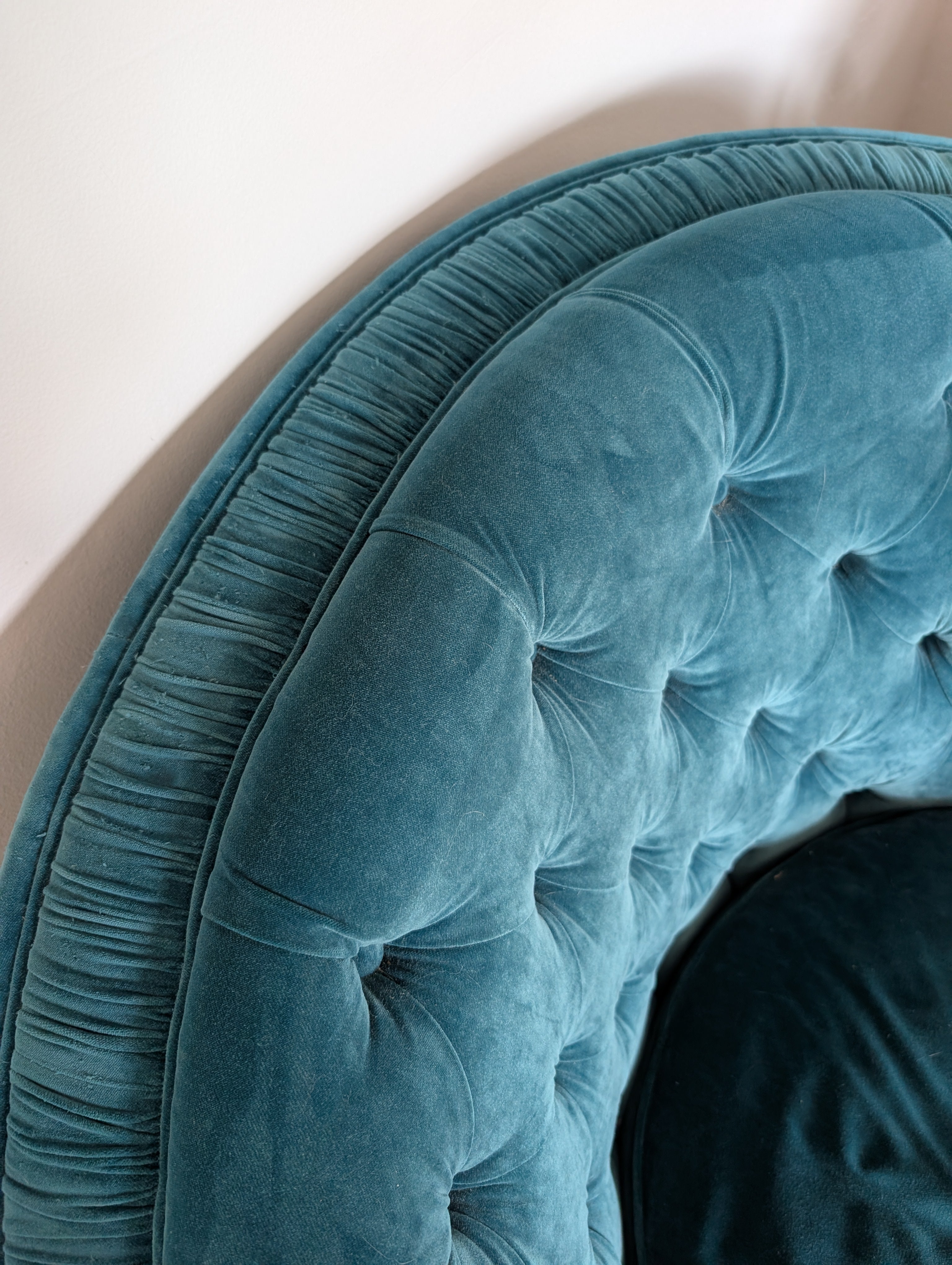 Close-up of a teal tufted headboard